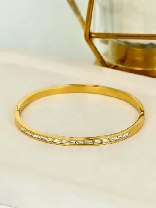 Pozłacana bransoletka sztywna typu bangle z cyrkoniami szlifu bagietkowego