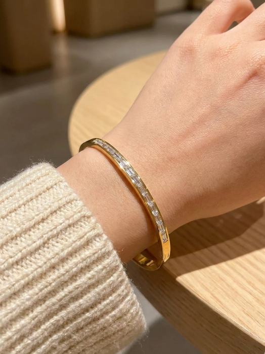 Pozłacana bransoletka sztywna typu bangle z cyrkoniami szlifu bagietkowego