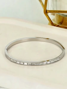 Srebrzysta bransoletka sztywna typu bangle z cyrkoniami szlifu bagietkowego