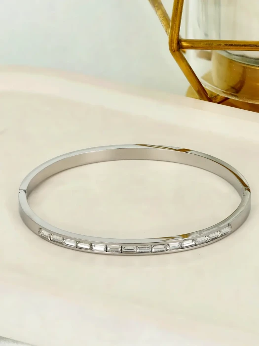 Srebrzysta bransoletka sztywna typu bangle z cyrkoniami szlifu bagietkowego