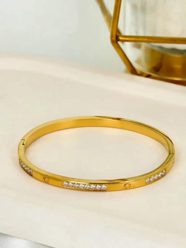 Pozłacana bransoletka sztywna typu bangle z motywem gwiazdek i cyrkoniami